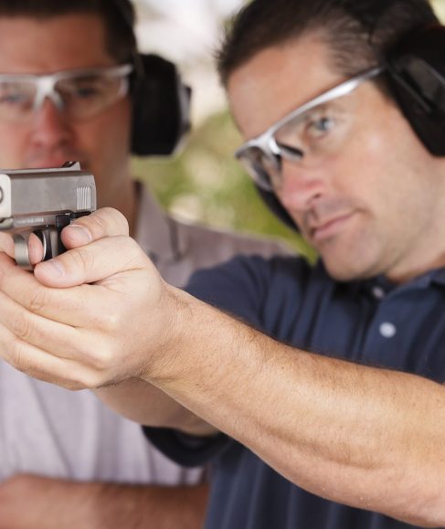Twp men practicing at the gun range. Photographed on location at a shooting range.